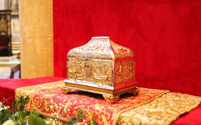 Gold ornate box on display in a treasury collection.