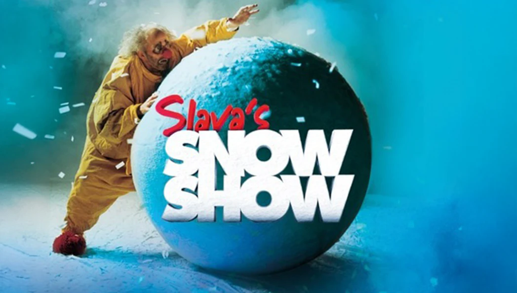 Performer in yellow suit with large snowball, Slava's Snowshow logo.