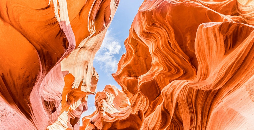 Lower Antelope Canyon's swirling sandstone formations under a clear blue sky.