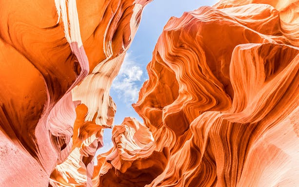 Lower Antelope Canyon's swirling sandstone formations under a clear blue sky.