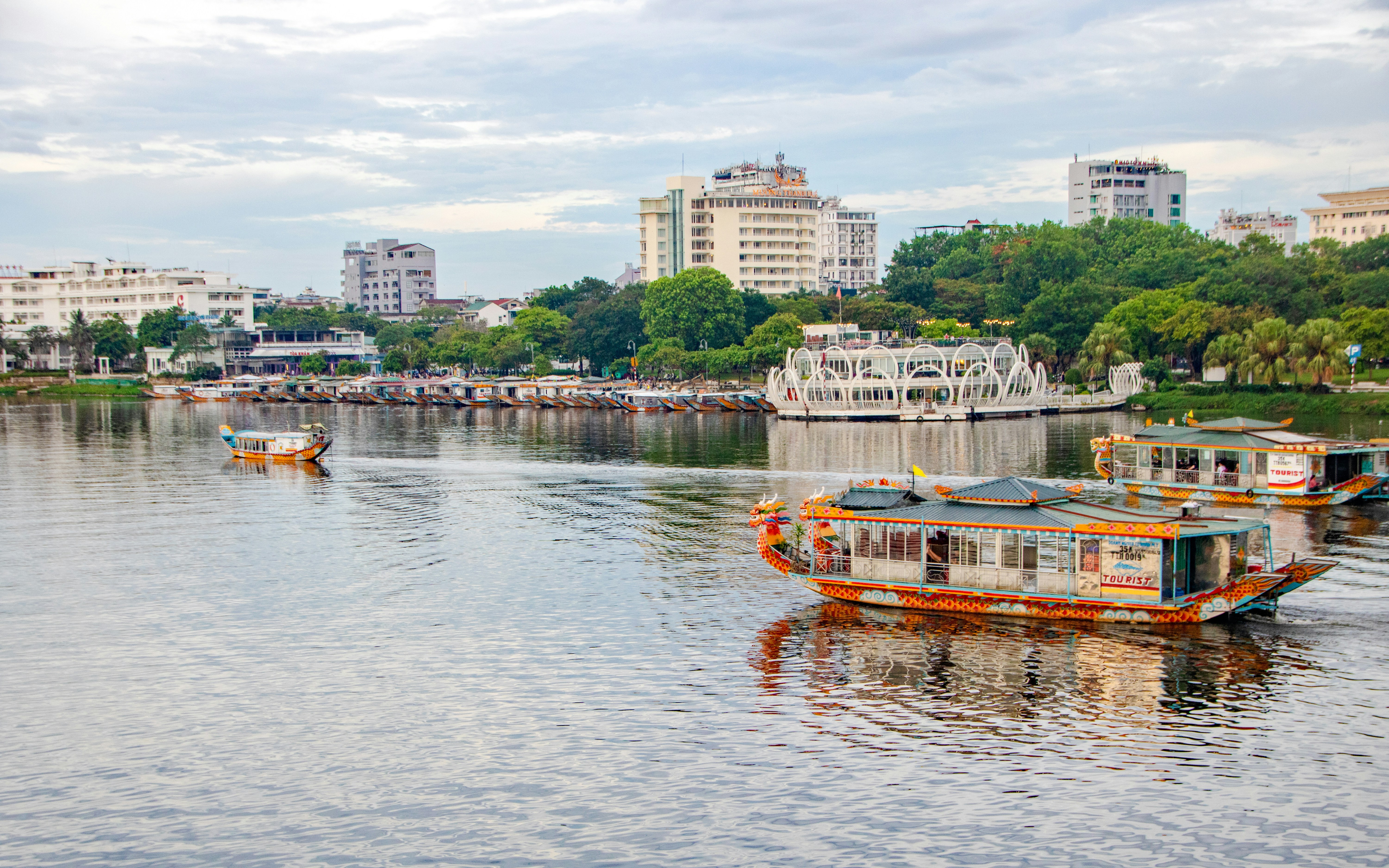 Tour boats on Perfume River with cityscape in Hue, Vietnam.