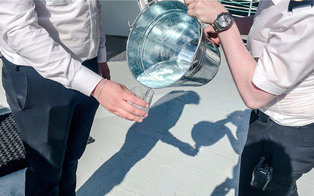 Pouring waterfall water into a glass, Geiranger, Norway.