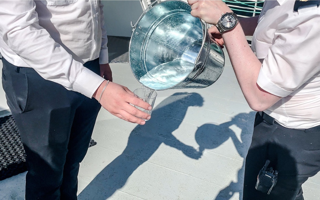 Pouring waterfall water into a glass, Geiranger, Norway.