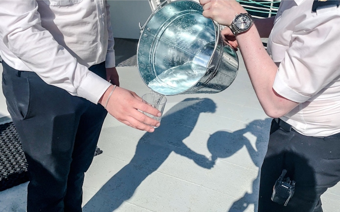 Pouring waterfall water into a glass, Geiranger, Norway.