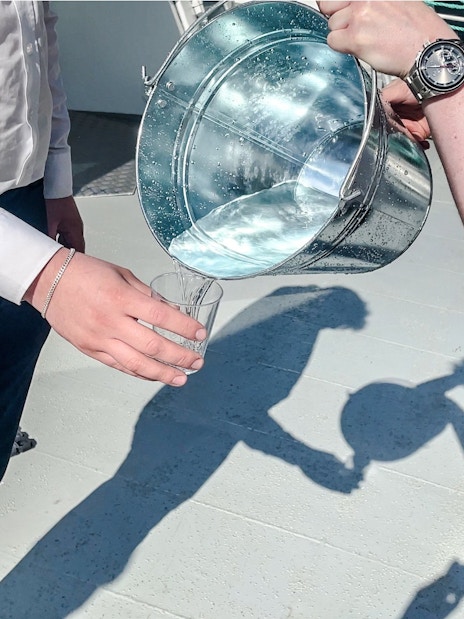 Pouring waterfall water into a glass, Geiranger, Norway.