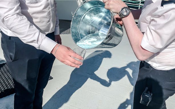 Pouring waterfall water into a glass, Geiranger, Norway.