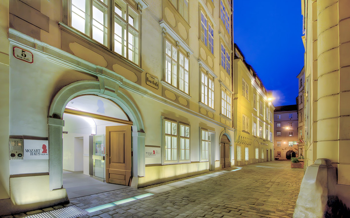 Mozarthaus Vienna entrance at night with open door and illuminated facade.