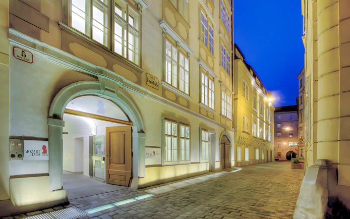 Mozarthaus Vienna entrance at night with open door and illuminated facade.