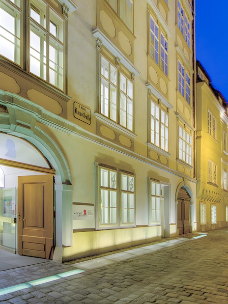 Mozarthaus Vienna entrance at night with open door and illuminated facade.