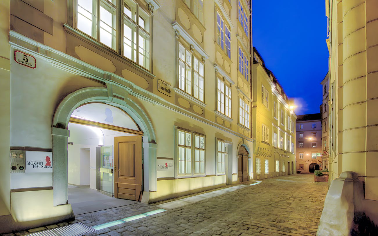 Mozarthaus Vienna entrance at night with open door and illuminated facade.
