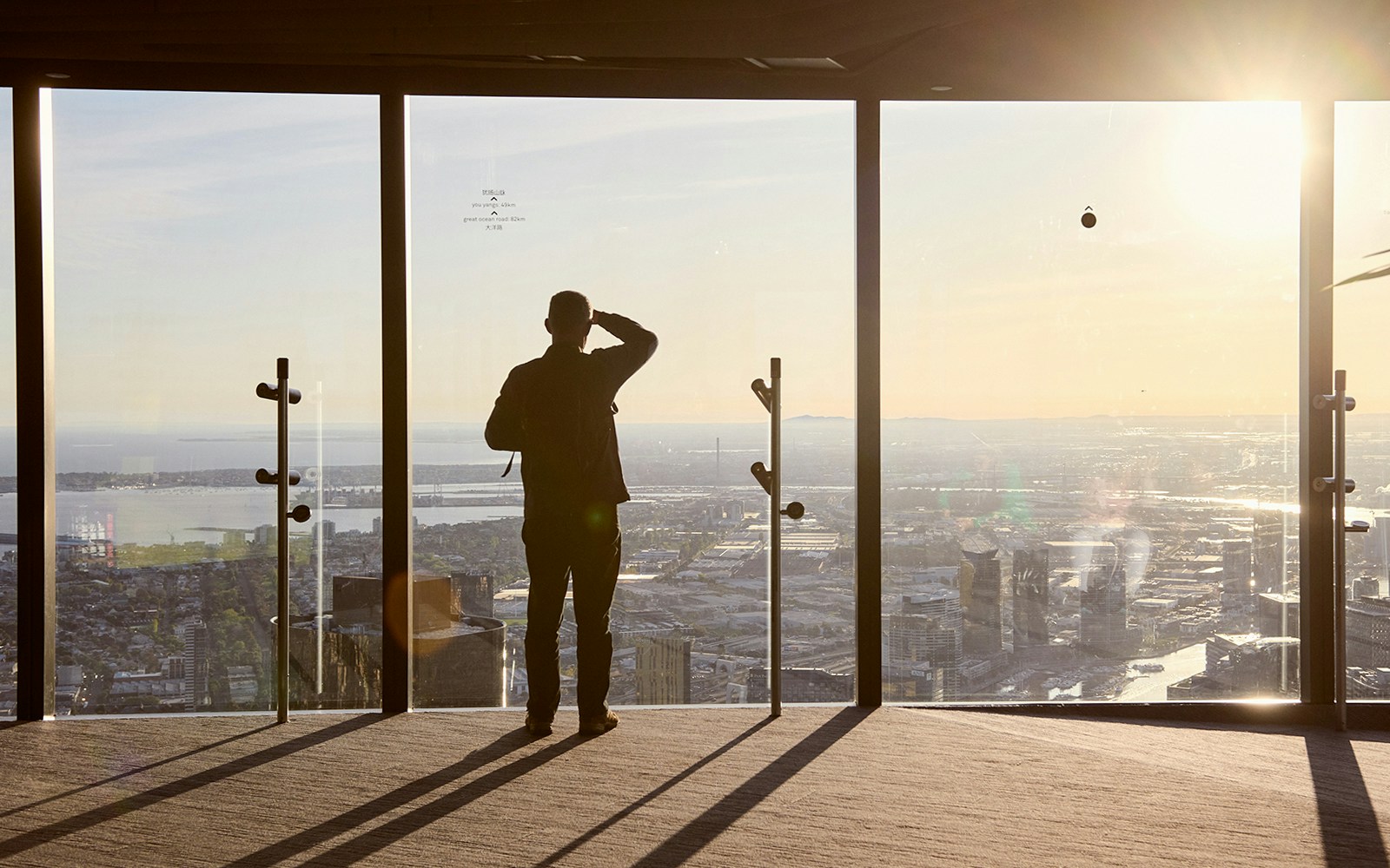 Person enjoying city view from Melbourne Skydeck at sunset, part of Max VR Experience.