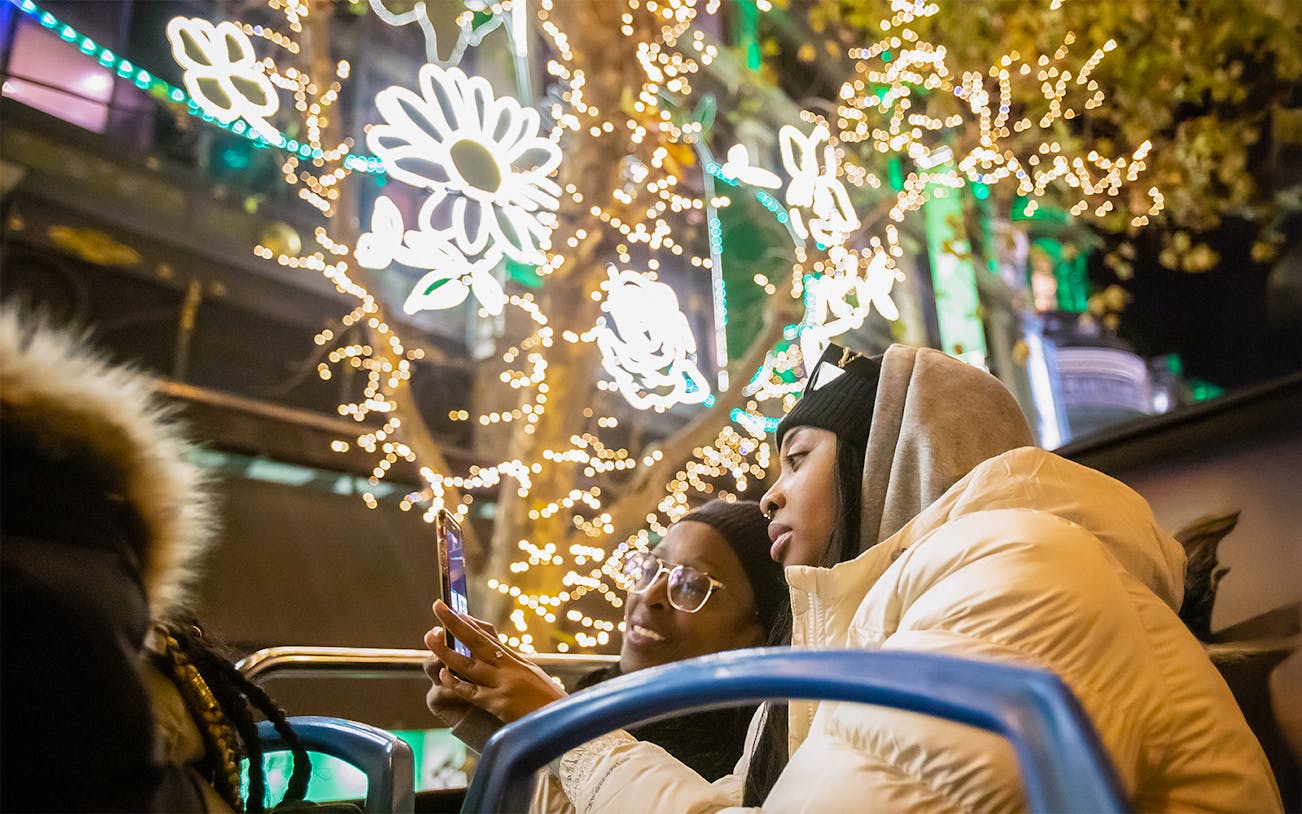Guests enjoying Christmas lights on a tour bus in Paris.