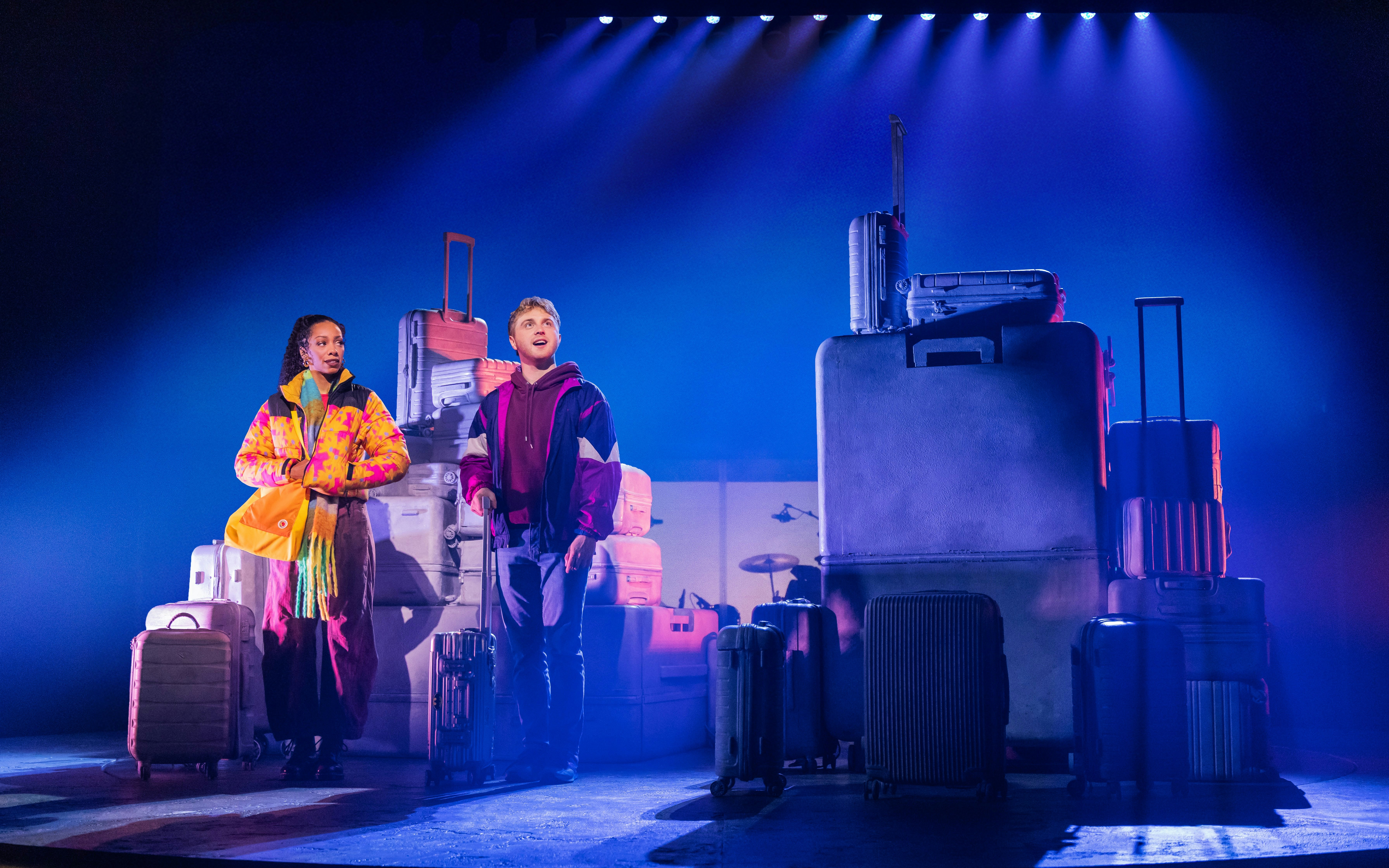 Two actors on stage with suitcases in "Two Strangers (Carry a Cake Across New York)" Broadway show.