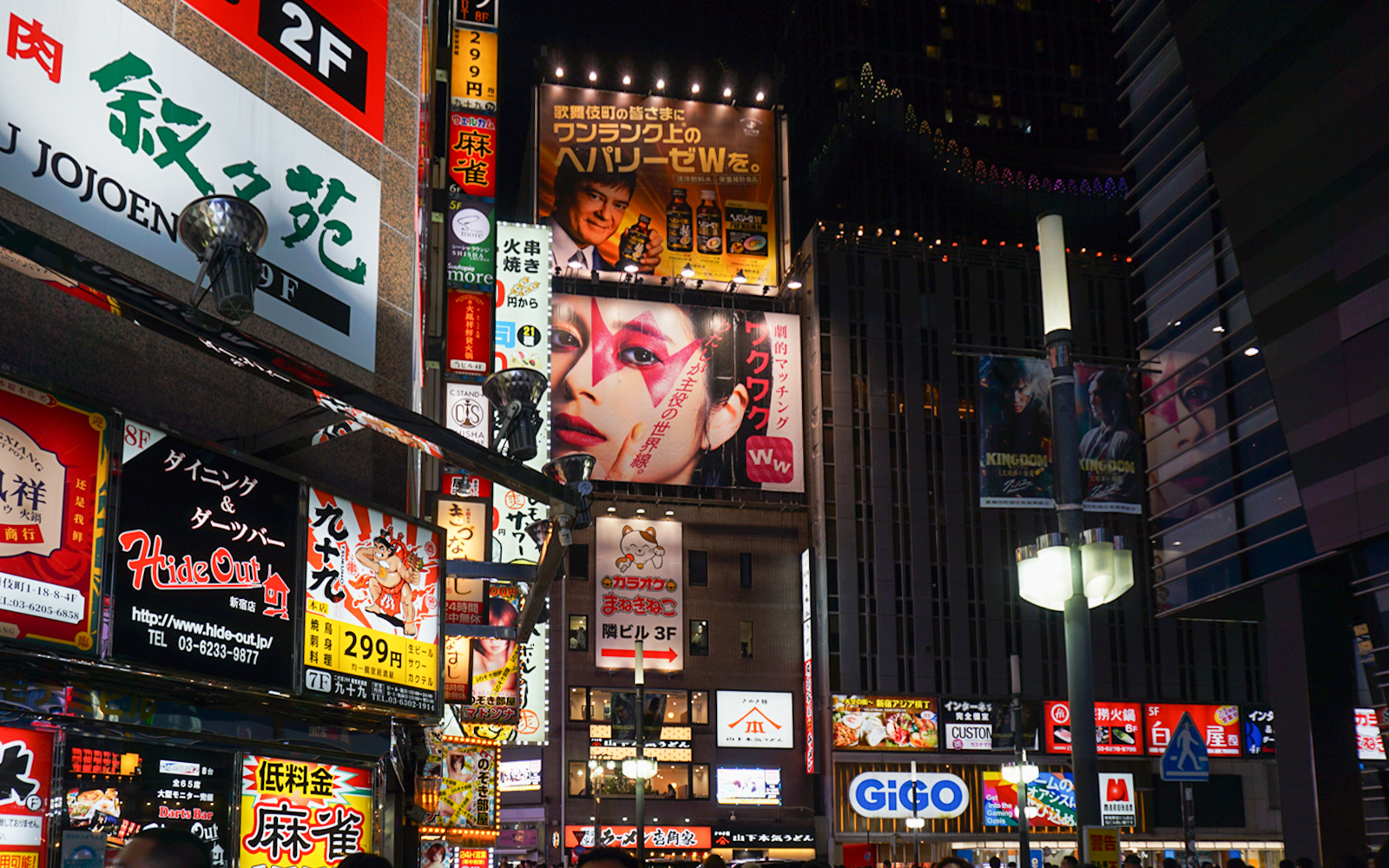 Shinjuku street view with neon signs and people enjoying night out, Tokyo.