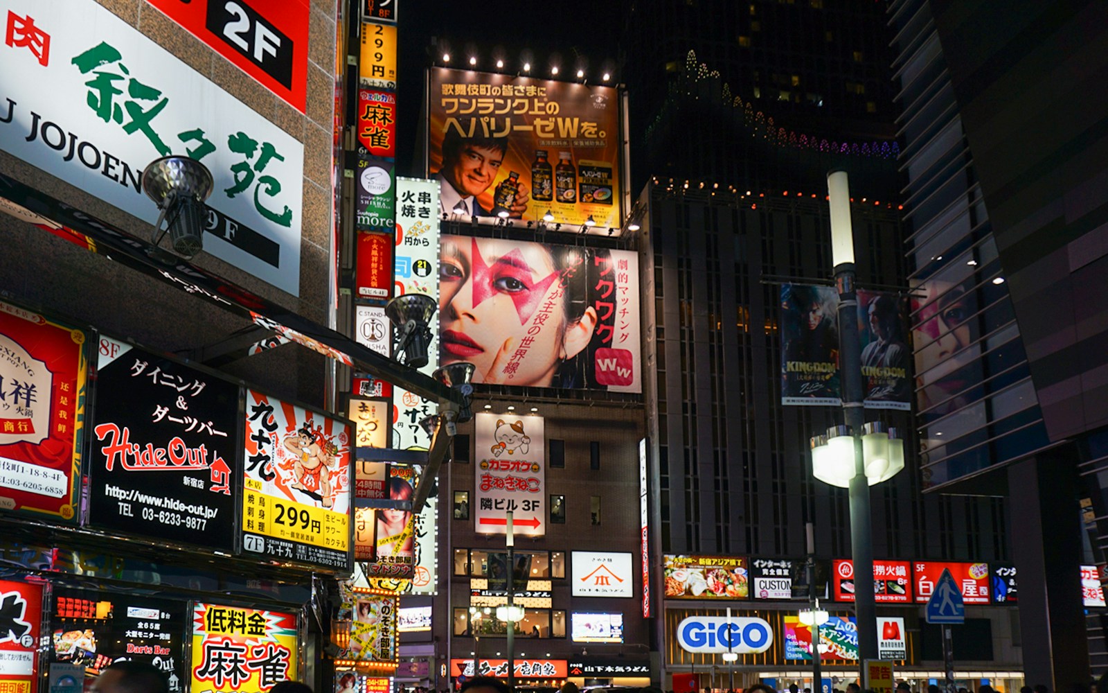 Shinjuku street at night with vibrant neon signs and billboards, Tokyo nightlife.