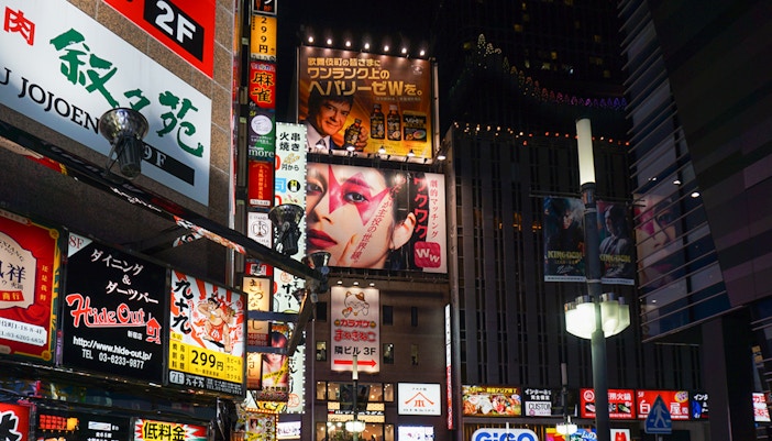 Shinjuku street view with neon signs and people enjoying night out, Tokyo.