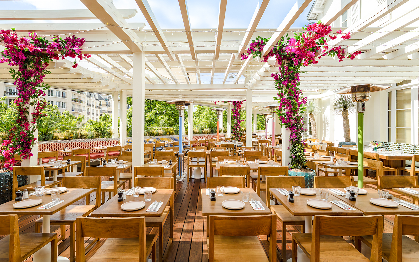 Brasserie Auteuil interior with wooden tables, chairs, and floral decorations.
