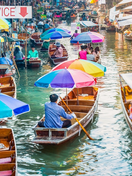 Boats with colorful umbrellas at Damnoen Saduak Floating Market, Thailand.