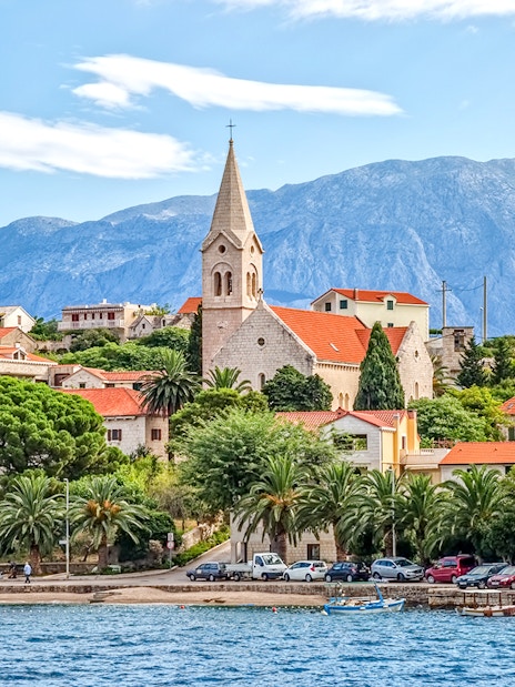 Coastal view of Bol Town with church and mountains on Brac Island, Croatia.
