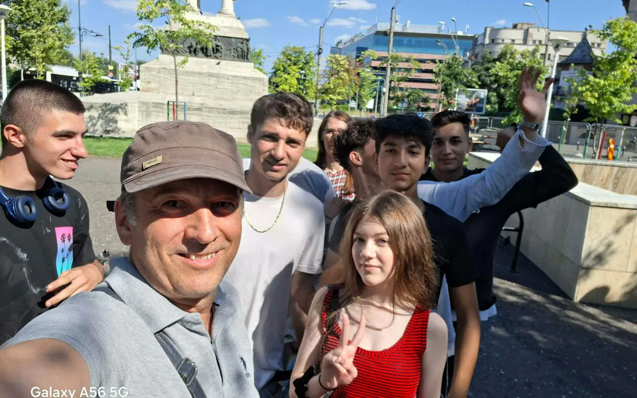 Group of people enjoying a sunny day near a monument in Bucharest during a self-guided city exploration game.