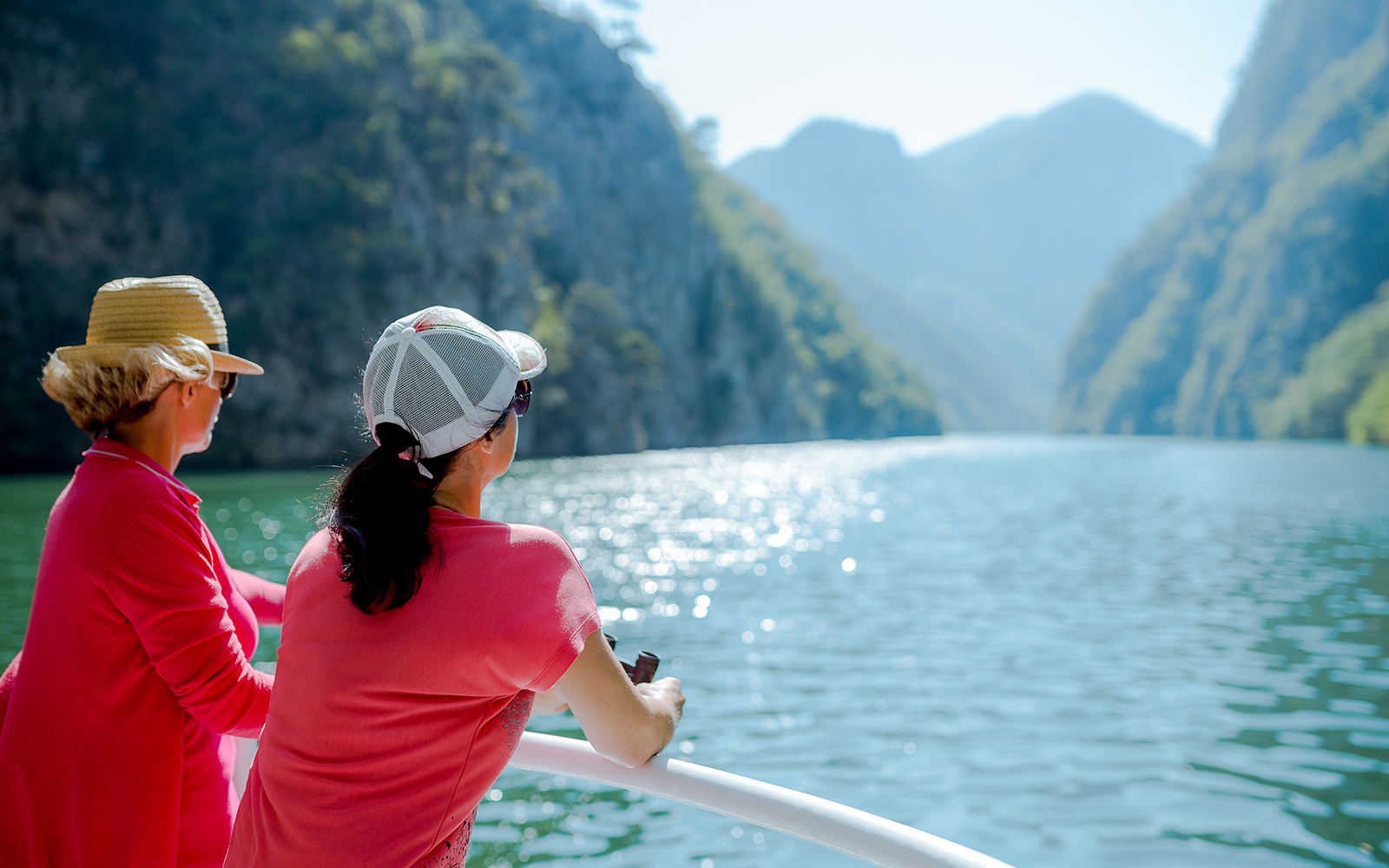 Tourists enjoying a boat ride with scenic views of Cinque Terre cliffs and water.