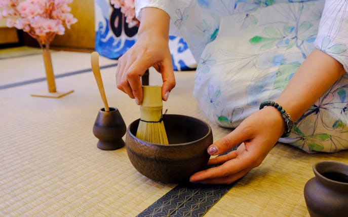 Tea ceremony preparation with bamboo whisk in Tokyo during spring.