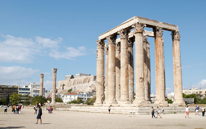Temple of Olympian Zeus ruins in Athens with Acropolis in the background.