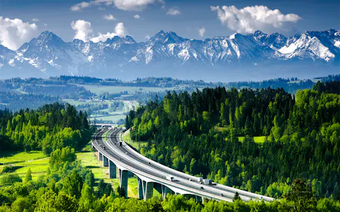 Highway through lush forest with Tatra Mountains in Zakopane, Poland, on a day trip from Krakow.