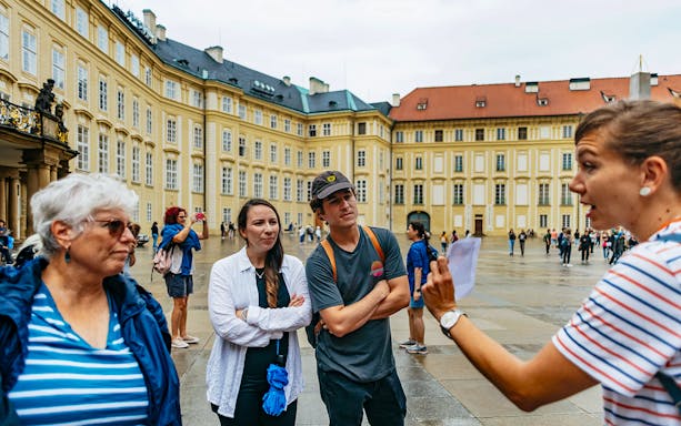 Guide explaining to visitors at Old Town Square, Prague.