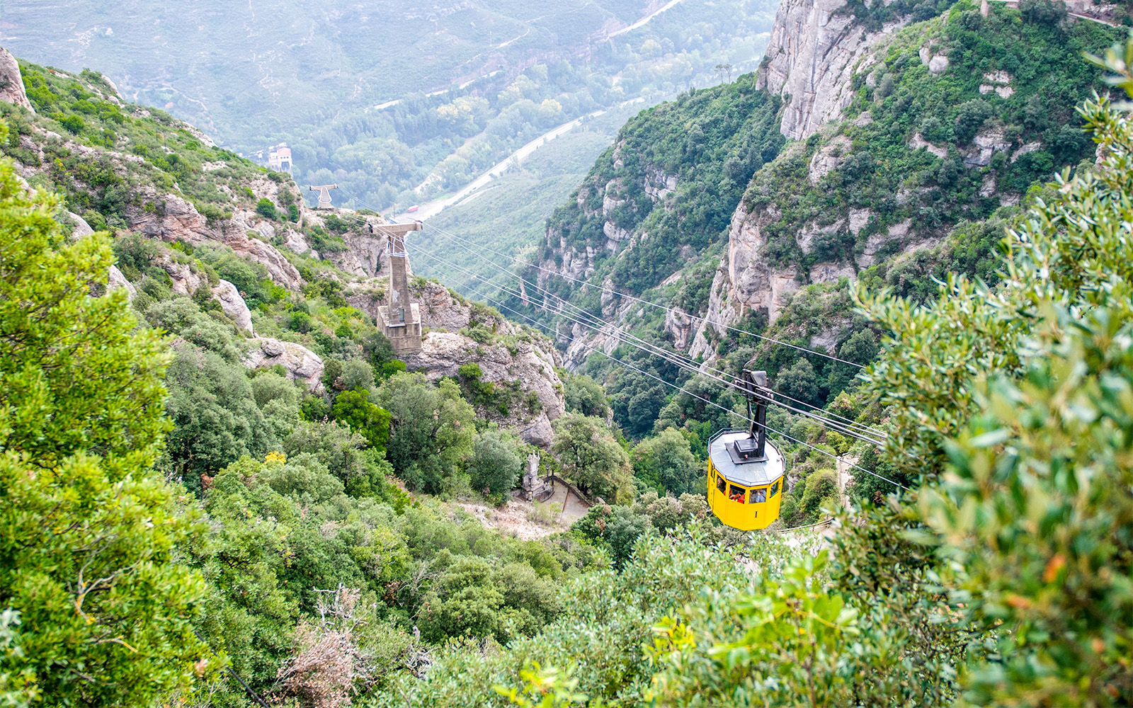Montserrat Monastery nestled in rocky mountain landscape through cable car, Catalonia, Spain.