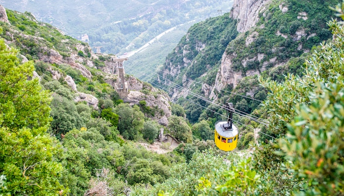 Montserrat Monastery nestled in rocky mountain landscape through cable car, Catalonia, Spain.