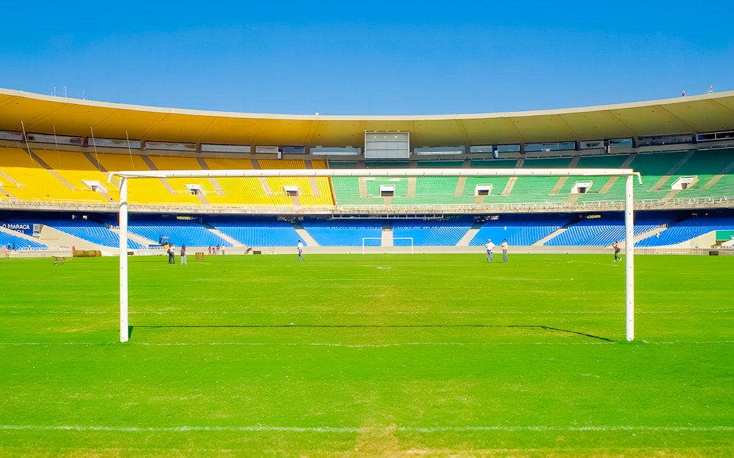Maracanã Stadium field with goalposts and colorful seating, Rio de Janeiro, Brazil.