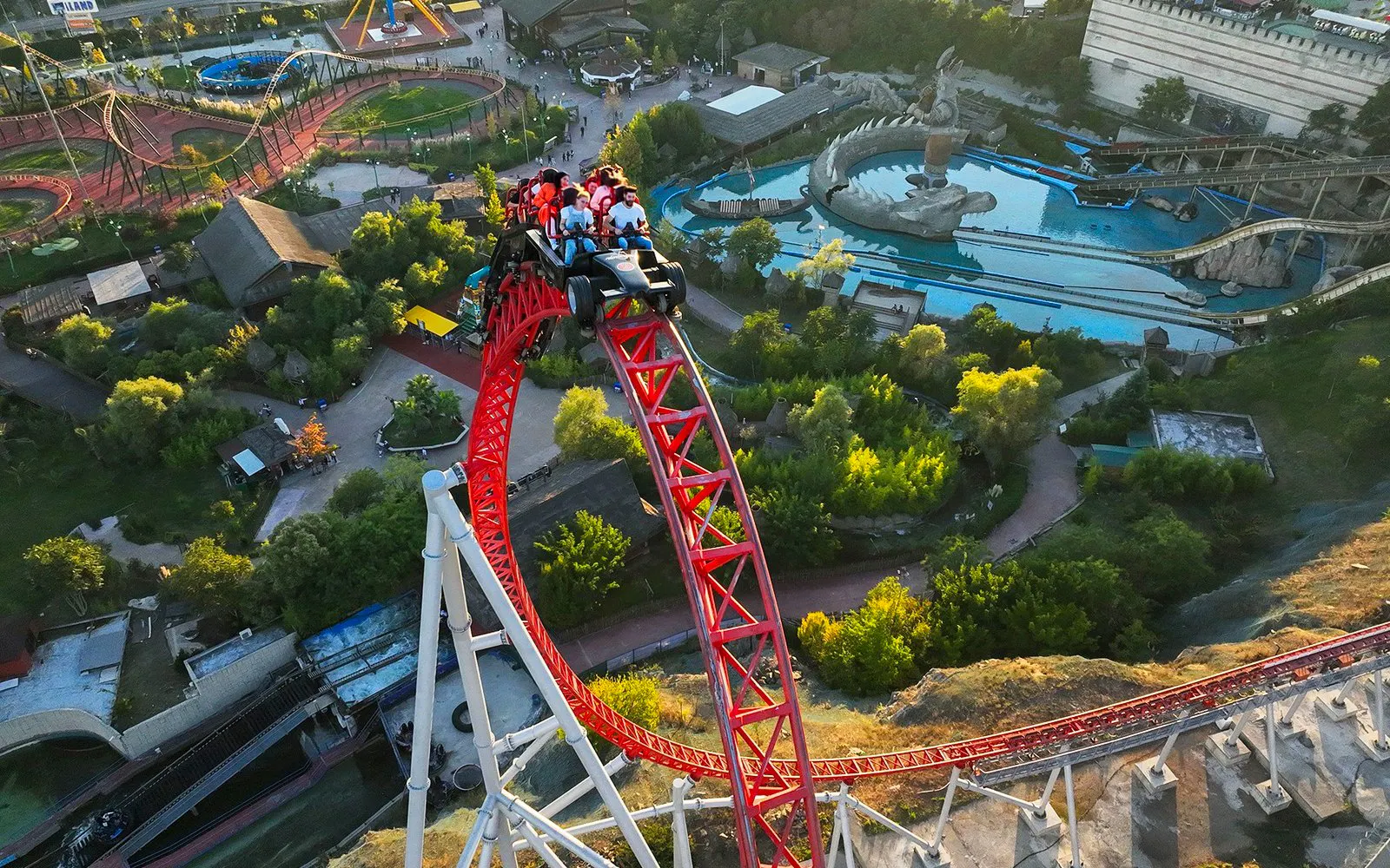 Roller coaster at Vialand Theme Park, Istanbul, with riders on a steep red track.