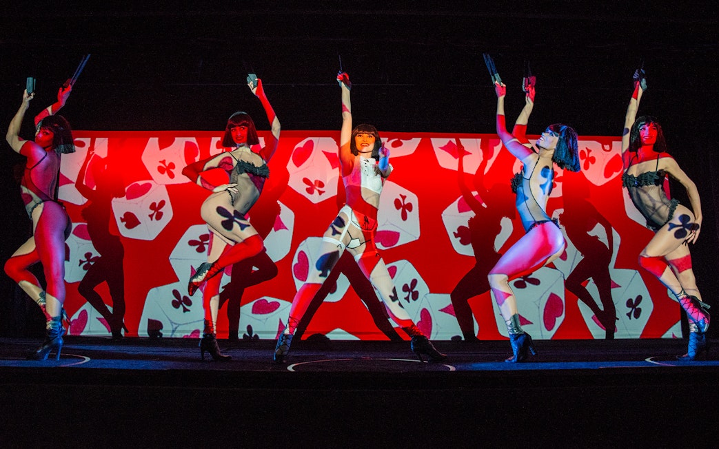 Performers on stage at Crazy Horse Cabaret Show with vibrant red and black backdrop.