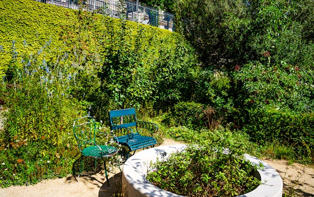 Chairs in the lush garden of Maison de Balzac, Paris.