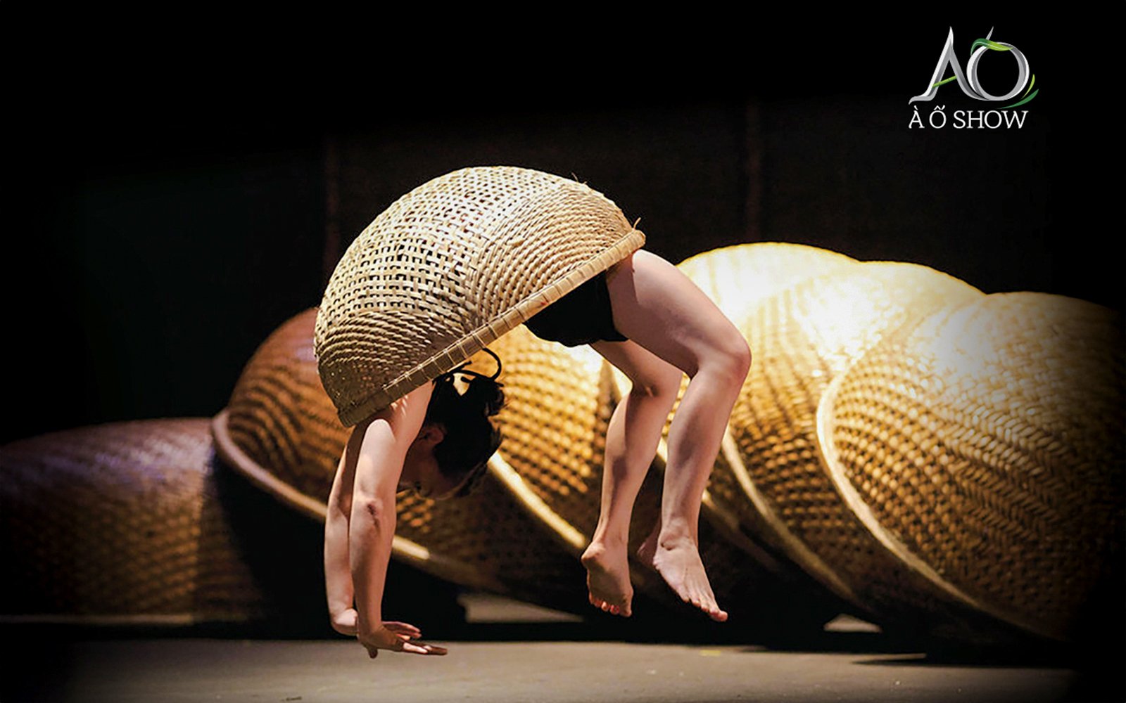 Performer balancing with cane basket at AO Show.