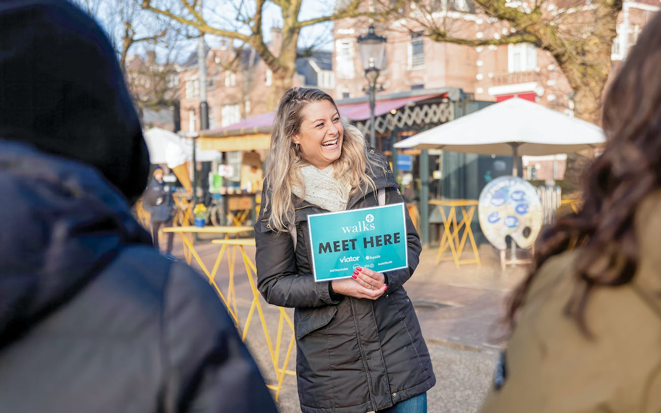 Tour guide holding a "Meet Here" sign for Van Gogh small group tour.