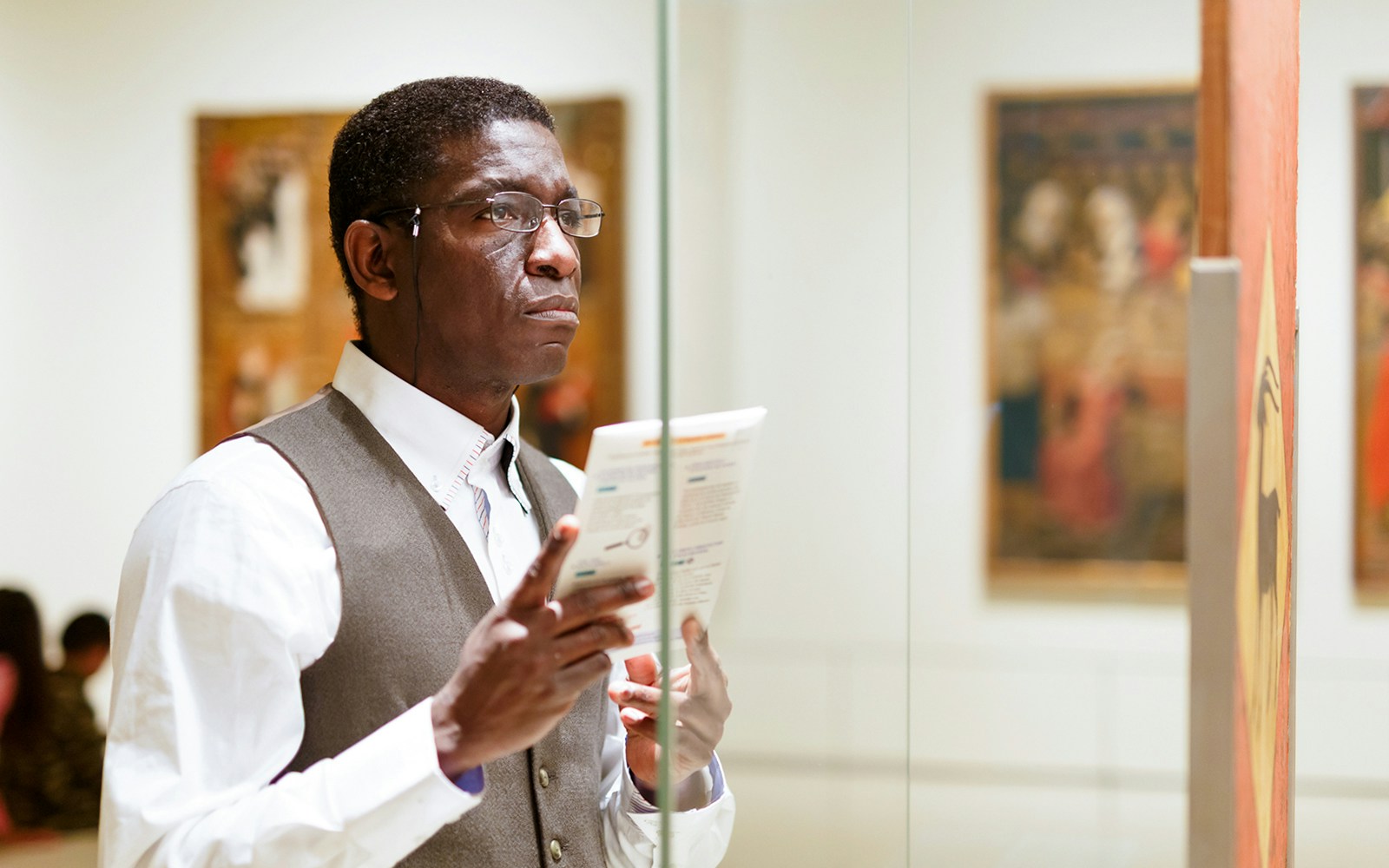 Man reading brochure at Hannibal Square Heritage Center museum exhibit.