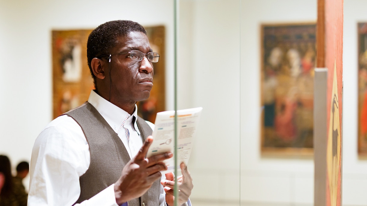 Man reading brochure at Hannibal Square Heritage Center museum exhibit.