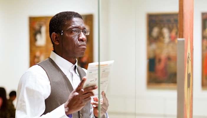 Man reading brochure at Hannibal Square Heritage Center museum exhibit.