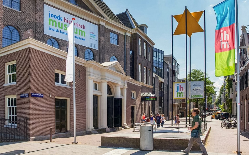 Exterior of Jewish Historical Museum in Amsterdam with entrance and flags.