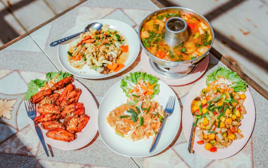 Thai dishes served on a table during a Krabi luxury longtail boat cruise.
