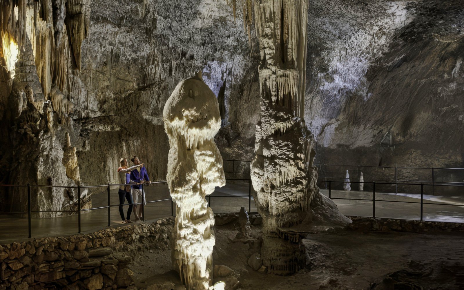 Guests exploring stalagmites in Postojna Cave, Slovenia.
