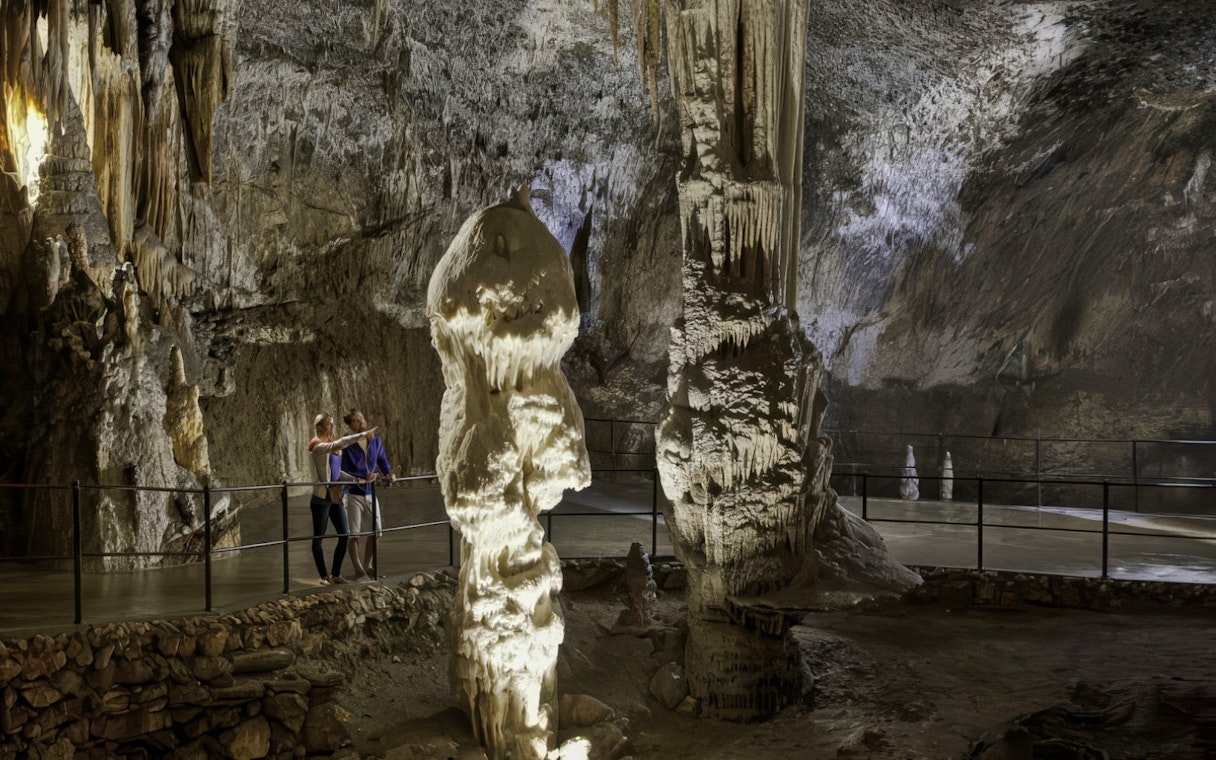 Guests exploring stalagmites in Postojna Cave, Slovenia.