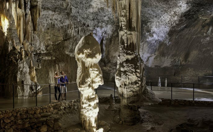 Guests exploring stalagmites in Postojna Cave, Slovenia.
