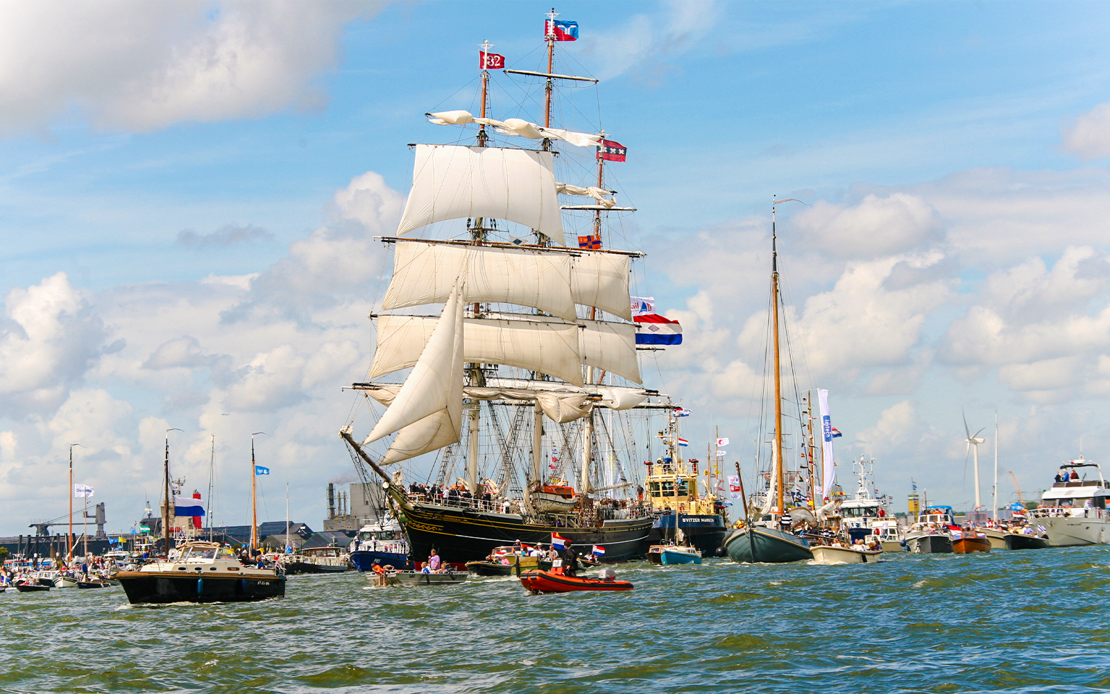 Sailboats in Amsterdam canal during Sail Amsterdam event.