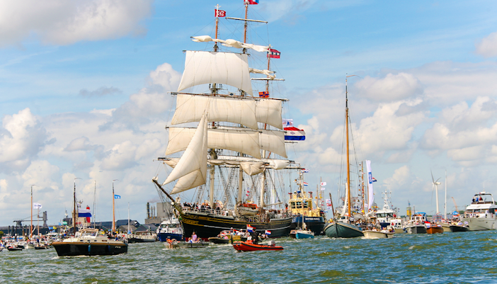 Tall ships and boats sailing during Sail Amsterdam event.