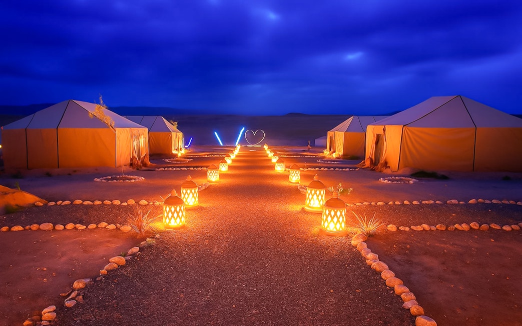 Night camp setup with lit lanterns in Agafay Desert, Marrakech.
