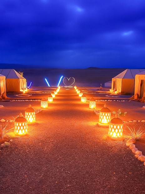Night camp setup with lit lanterns in Agafay Desert, Marrakech.