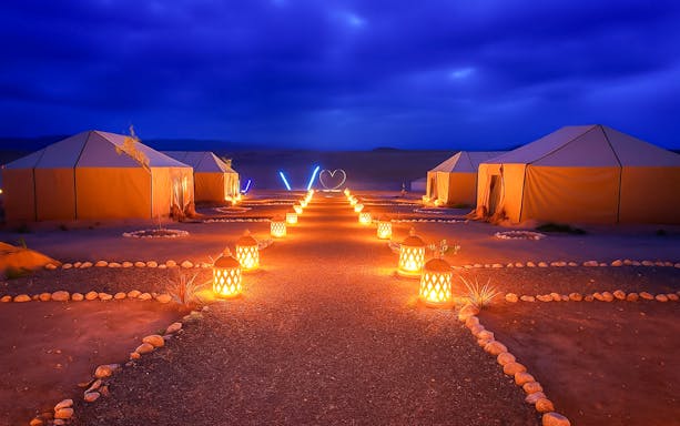 Night camp setup with lit lanterns in Agafay Desert, Marrakech.